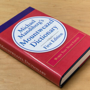 A large hardbound book with a red cover on a maple wood table